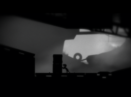 A screenshot from Limbo, showing the protagonist pushing some boxes.