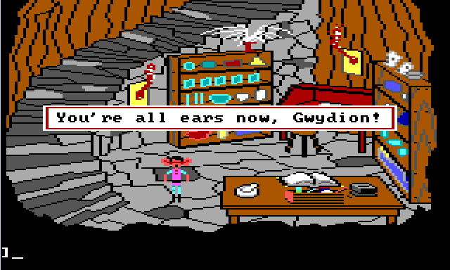 Gwydion stands in a stone basement. Large stone stairs lead down to it. The walls are lined with shelves containing lots of beakers and jars. There is a red desk in one corner. In the foreground is a wide table with a large book on it and alchemical tools scattered around. Gwydion stands by the table. He has very large ears and looks surprised. Game text reads: "You're all ears now, Gwydion!"