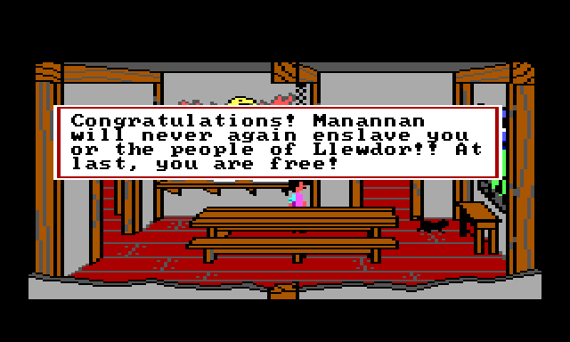 Gwydion and a black cat in the dining room. Game text reads: "Congratulations! Manannan will never again enslave you or the people of Llewdor! At last, you are free!"