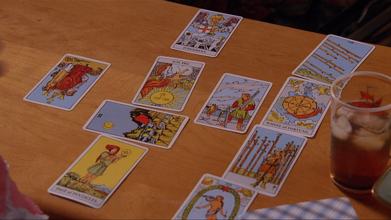 A screen capture of Anna's spread from "The Mountain King." The cards are laid in a Celtic Cross on a coffee table. There is a glass of iced tea next to the spread.