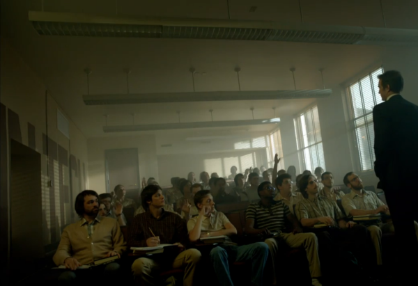 Still from Halt and Catch Fire. A man in a suit stands in front of a classroom full of men in 80's clothes. A few of the students are raising their hands.